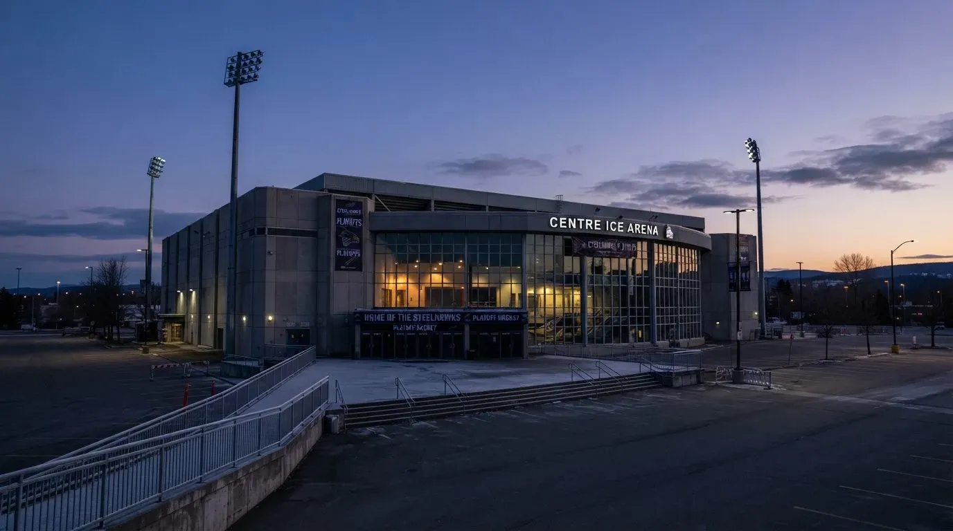 An empty football stadium with floodlight masts at dusk