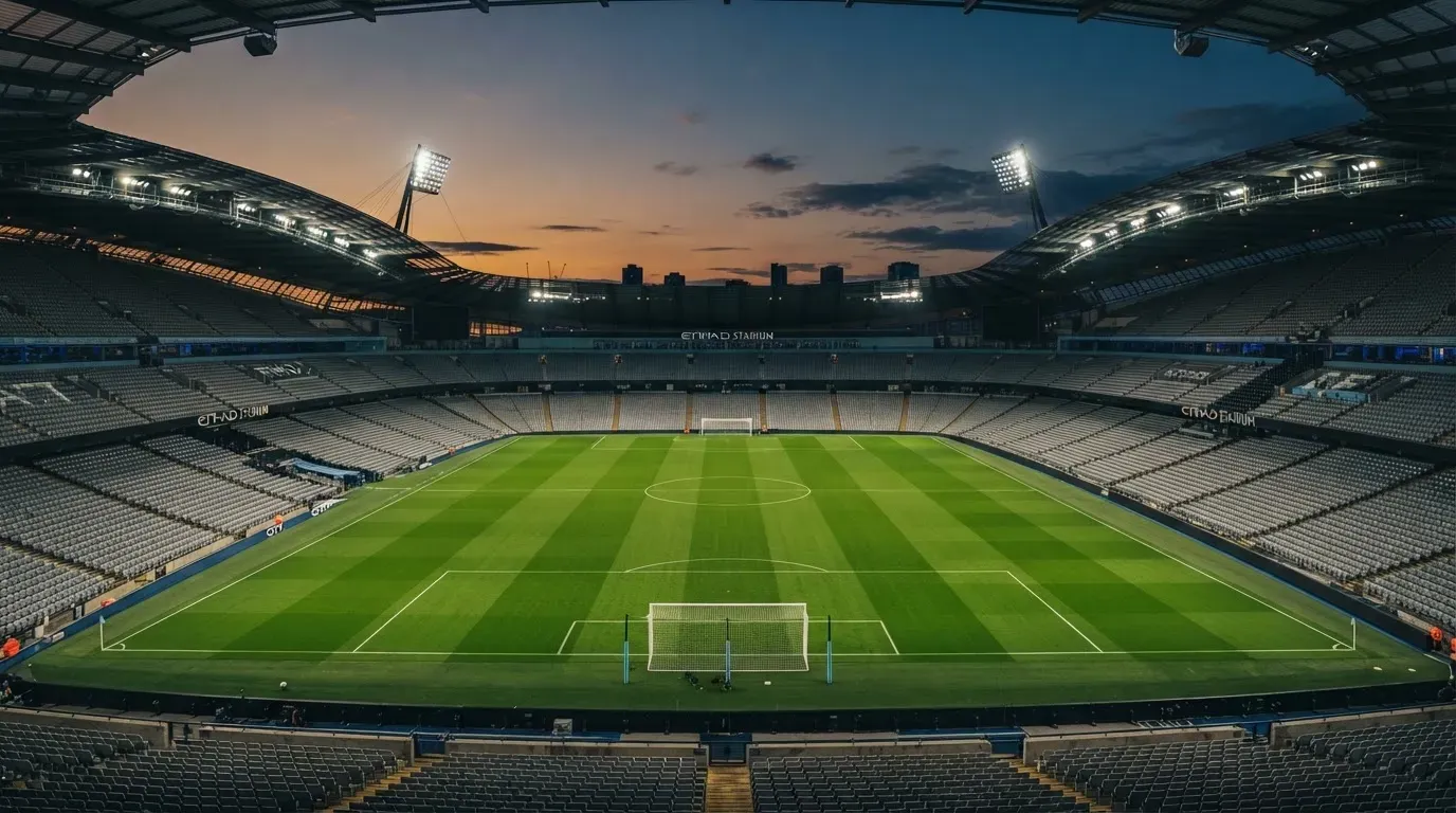 An empty football stadium with floodlight masts at dusk